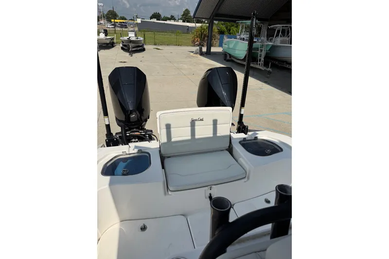 Slide: The Image of 2021 Sea Cat 260 boat with dual engines, docked outdoors. - 17