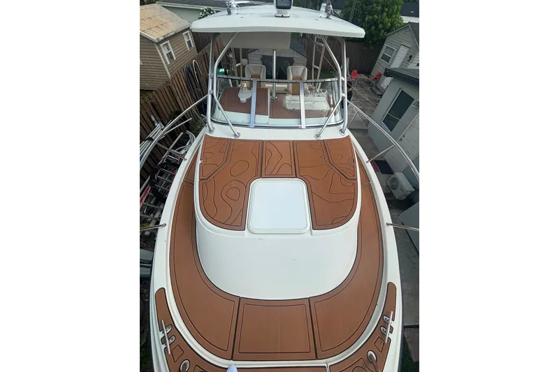 Slide: The Image of 2004 Hydra-Sports Vector 2800 WA boat with brown deck, docked near houses. - 19