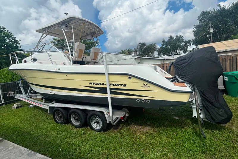 The Image of 2004 Hydra-Sports Vector 2800 WA boat on trailer, parked on grass, under cloudy sky. - 1
