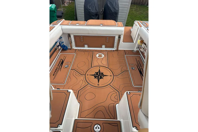 Slide: The Image of 2004 Hydra-Sports Vector 2800 WA boat deck with compass design and storage compartments. - 18