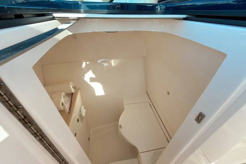 Slide: The Image of 2015 Pursuit DC 325 Dual Console boat interior cabin with storage and seating. - 9