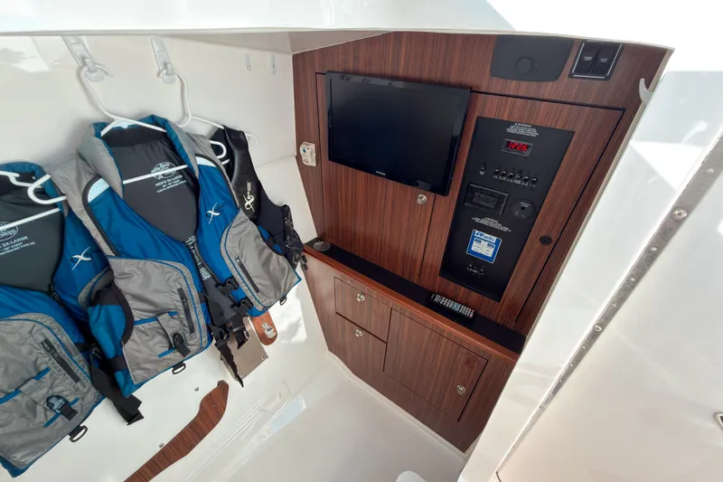 Slide: The Image of Interior of 2015 Pursuit DC 325 Dual Console with life jackets and control panel. - 11