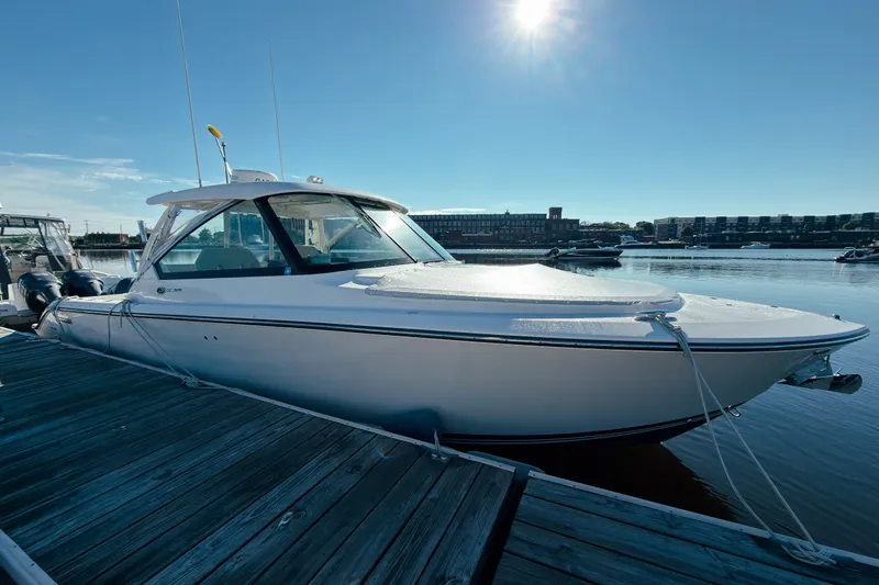 The Image of 2015 Pursuit DC 325 Dual Console boat docked on a sunny day. - 0