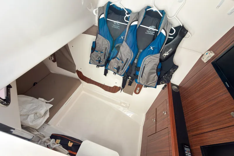Slide: The Image of Interior cabin of 2015 Pursuit DC 325 Dual Console with life jackets and storage. - 10
