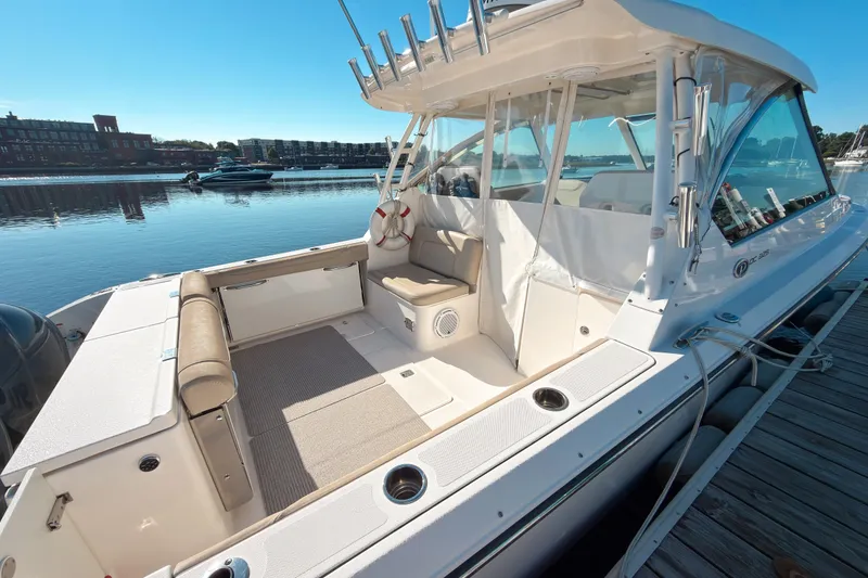 Slide: The Image of 2015 Pursuit DC 325 Dual Console boat docked, showcasing spacious seating and sleek design. - 1