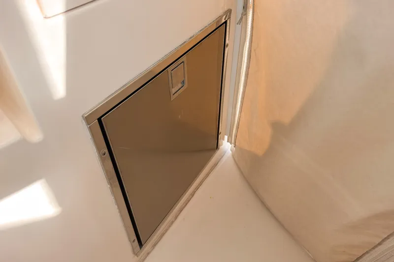 Slide: The Image of Storage compartment on a 2015 Pursuit DC 325 Dual Console boat interior. - 14