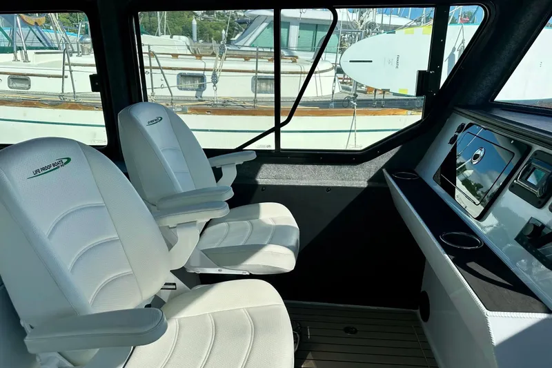 Slide: The Image of Interior of 2023 Life Proof 41 full cabin boat with white seating and control panel. - 13