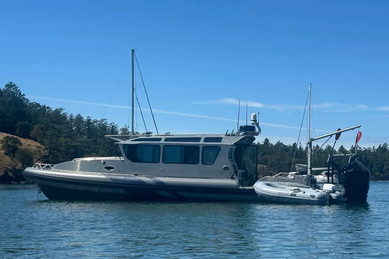 Slide: The Image of 2023 Life Proof 41 full cabin boat anchored on calm water with trees in background. - 2