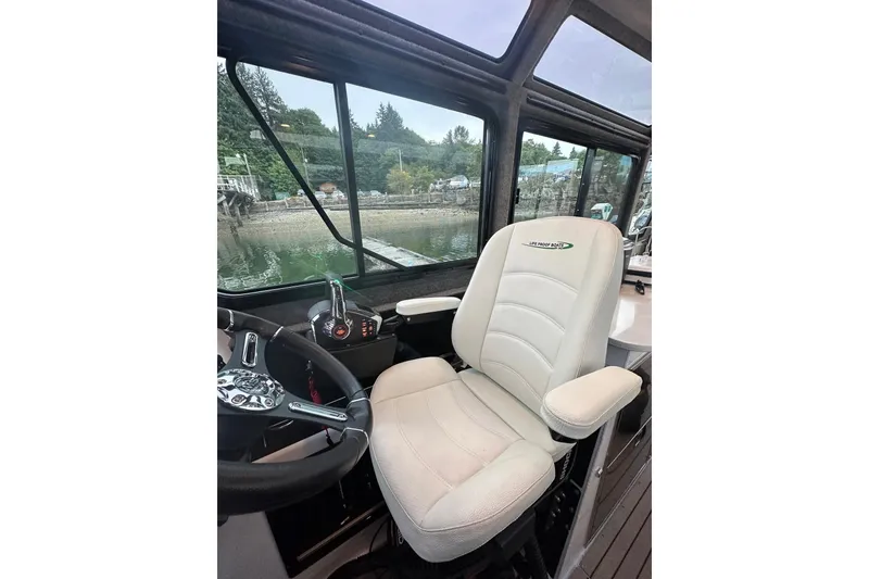 Slide: The Image of Captain's seat in 2023 Life Proof 41 full cabin boat, overlooking serene waters. - 42