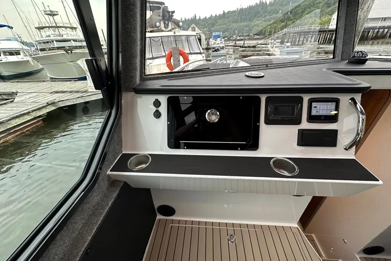 Slide: The Image of Interior view of 2023 Life Proof 41 full cabin boat, featuring control panel and dockside scenery. - 41