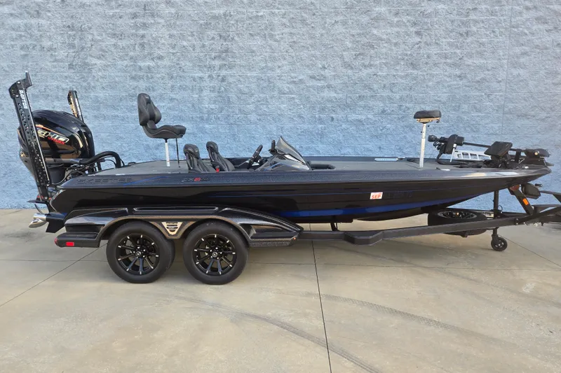The Image of 2025 Skeeter FXR20 bass boat with dual axle trailer, parked on concrete. - 1