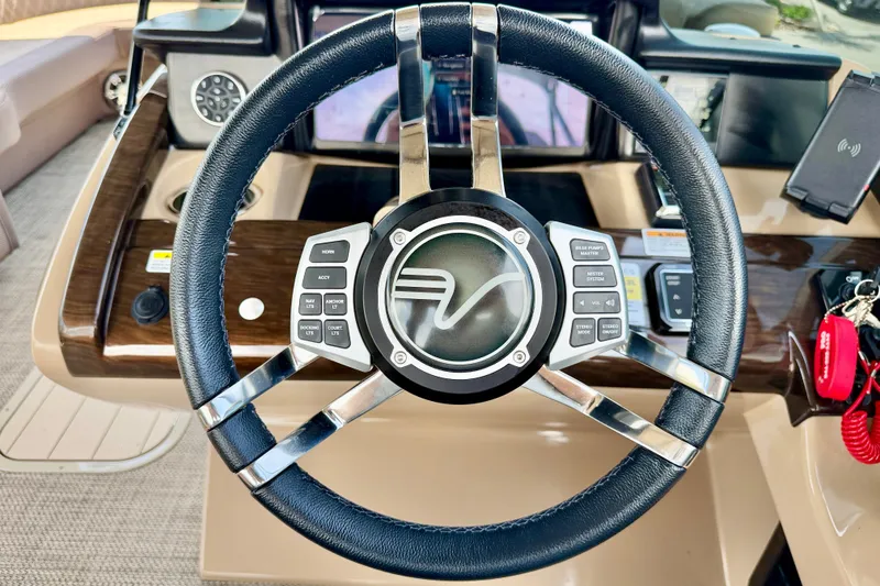 Slide: The Image of Steering wheel of a 2027 Vanderbilt 700T boat with control buttons and dashboard. - 23