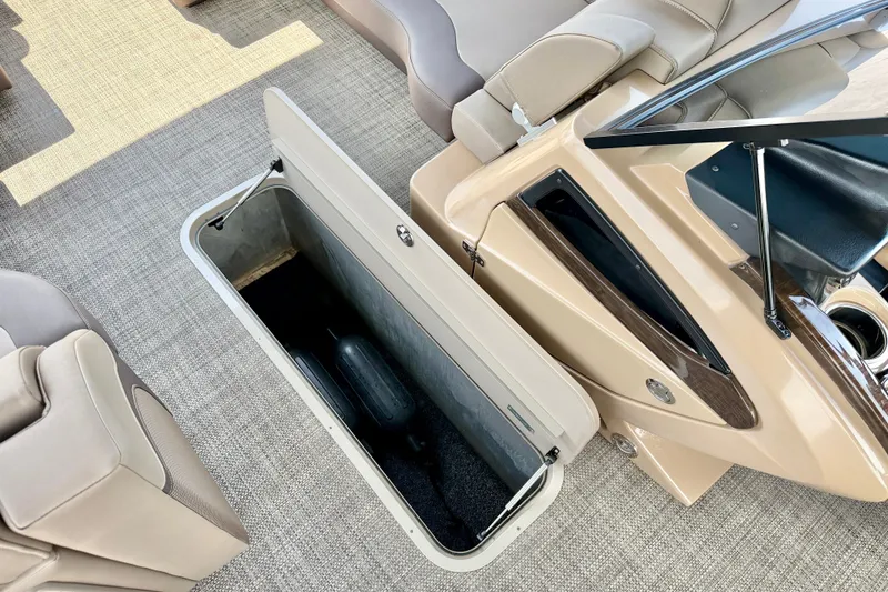 Slide: The Image of Open storage compartment in a 2027 Vanderbilt 700T boat interior, featuring beige seating and carpet. - 29
