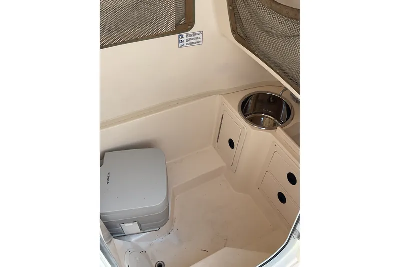 Slide: The Image of Interior of a 2002 Grady-White Chase 273 boat with portable toilet and storage compartments. - 13