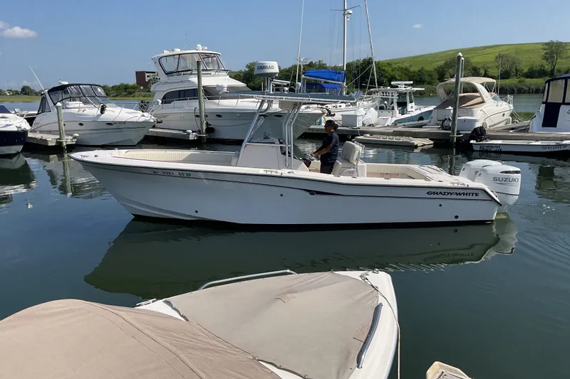 The Image of 2002 Grady-White Chase 273 boat docked in a marina with other vessels. - 0