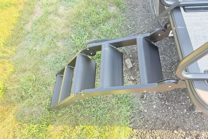Slide: The Image of Bentley Pontoons 2026 Fish 220 Fish-N-Cruise ladder on grassy terrain. - 25