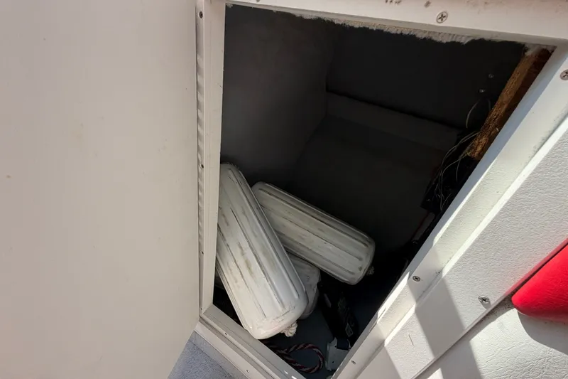 Slide: The Image of Storage compartment in a 2006 Crownline 266 BR boat with white fenders inside. - 13