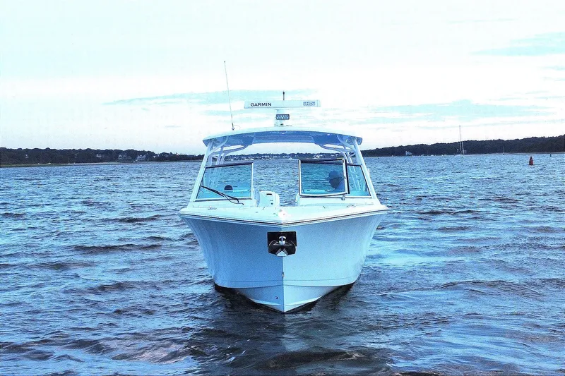 Slide: The Image of 2023 Cobia 330 Dual Console boat on calm waters at sunset. - 5