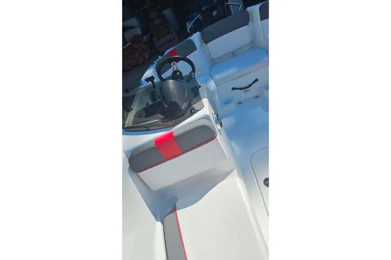Slide: The Image of 2022 Tahoe T16 boat interior with steering wheel and seating, featuring red and gray accents. - 16