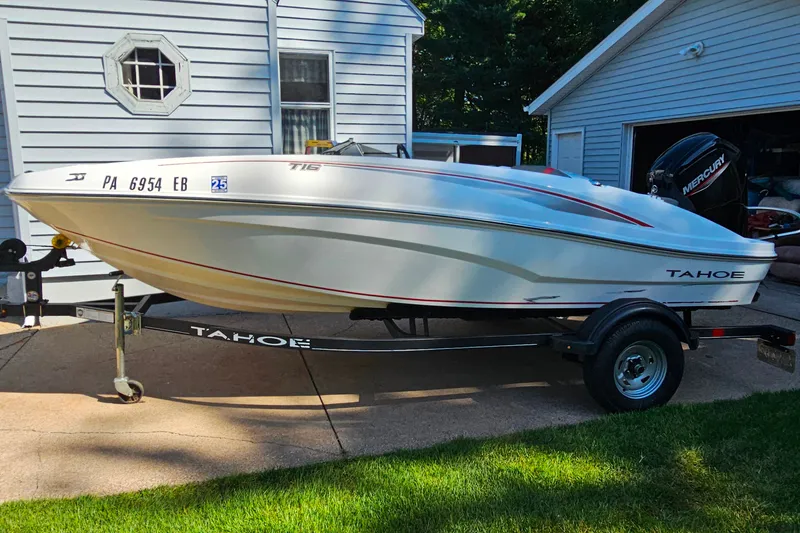 The Image of 2022 Tahoe T16 boat on trailer, parked beside a house. - 1