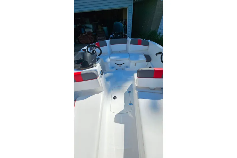 Slide: The Image of 2022 Tahoe T16 boat interior with red and gray seating, steering wheel visible. - 20