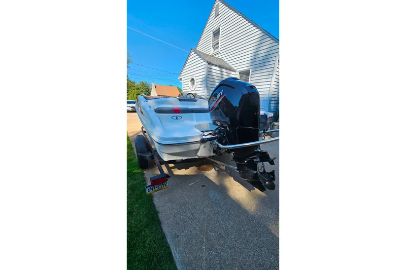 Slide: The Image of 2022 Tahoe T16 boat with Mercury outboard motor parked on driveway. - 2