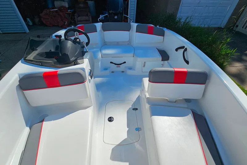 Slide: The Image of 2022 Tahoe T16 boat interior with red and gray seating, steering wheel, and dashboard. - 7