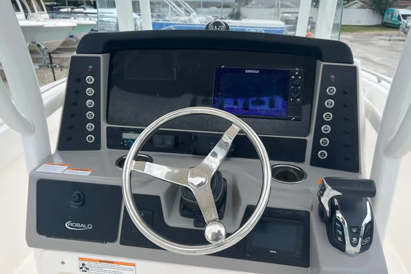 Slide: The Image of 2025 Robalo R230 Center Console dashboard with steering wheel and navigation display. - 7