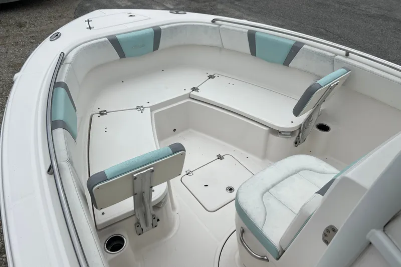 Slide: The Image of 2025 Robalo R230 Center Console boat interior with cushioned seating and storage compartments. - 8