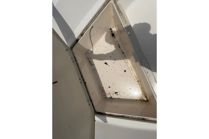 Slide: The Image of Open storage compartment on 2005 McKee Craft Marathon 172 CC boat, showing dirt and debris. - 15