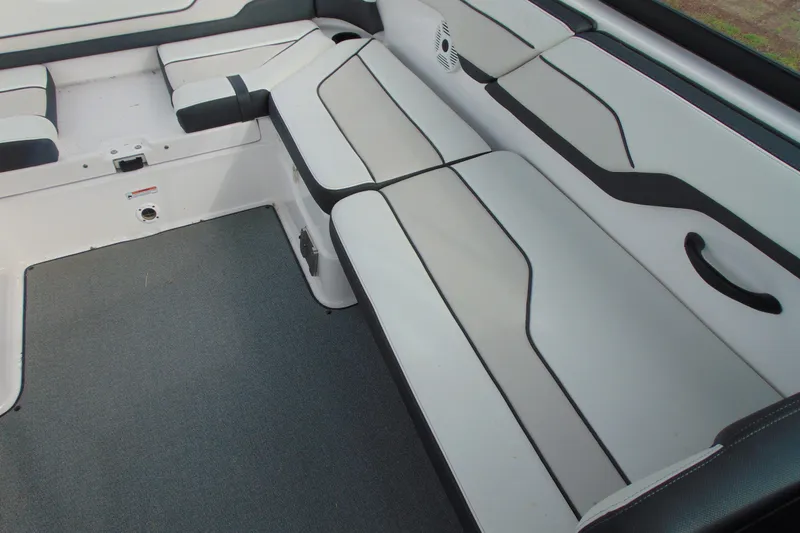 Slide: The Image of Interior seating of a 2018 Yamaha Boats SX210, featuring sleek white and black upholstery. - 14