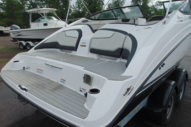 Slide: The Image of 2018 Yamaha Boats SX210 on trailer, featuring spacious rear deck and seating area. - 4