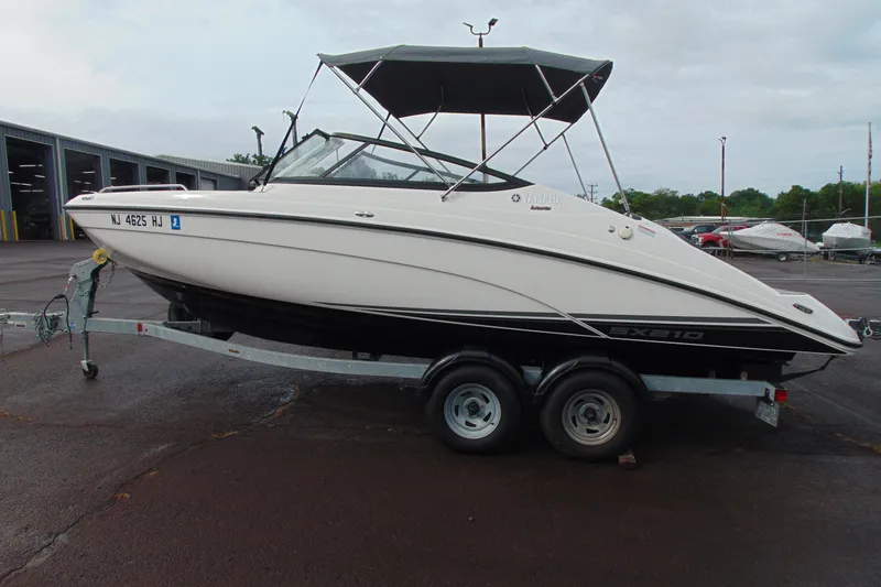 Slide: The Image of 2018 Yamaha Boats SX210 on trailer, parked outdoors with canopy. - 6