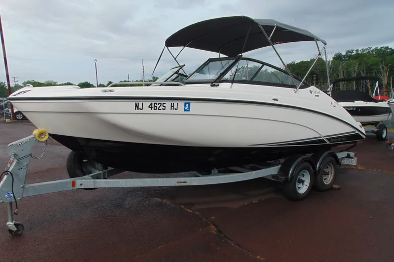 Slide: The Image of 2018 Yamaha Boats SX210 on trailer, white hull, parked outdoors. - 7