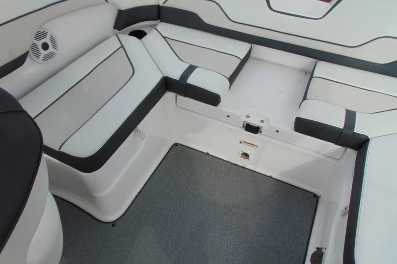 Slide: The Image of 2018 Yamaha Boats SX210 interior seating area with cushioned benches and speaker. - 15