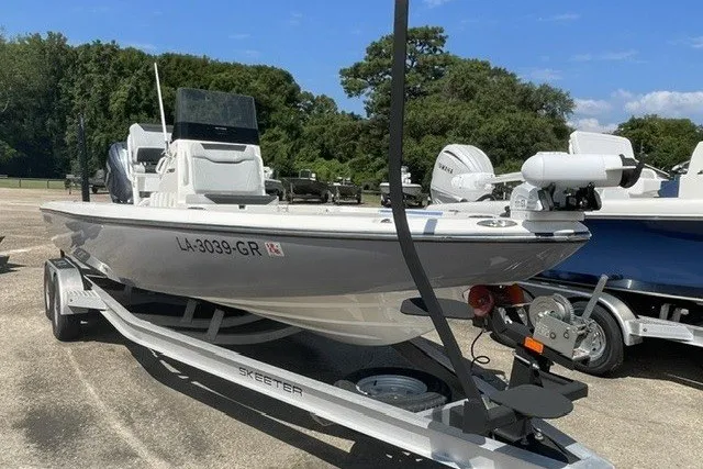 Slide: The Image of 2024 Skeeter SX241 boat on trailer, parked outdoors, showcasing sleek design and modern features. - 3
