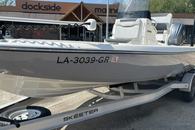 The Image of 2024 Skeeter SX241 boat on trailer at dockside marine dealership. - 0