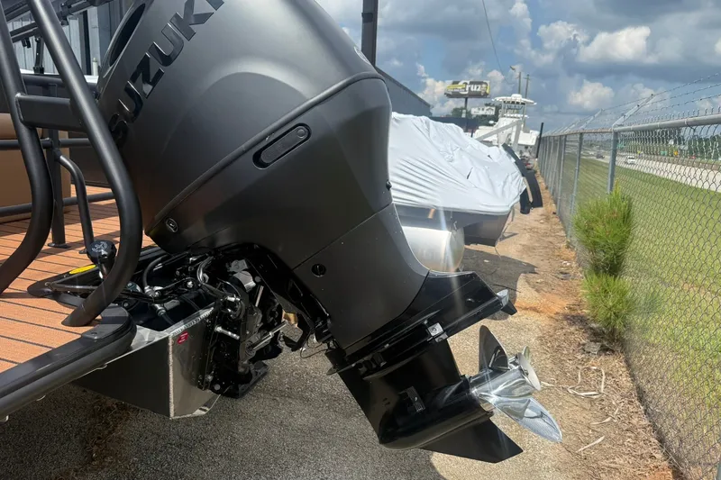 Slide: The Image of 2026 Bentley Pontoons Legacy 223 Swingback with Suzuki outboard motor, parked outdoors. - 19