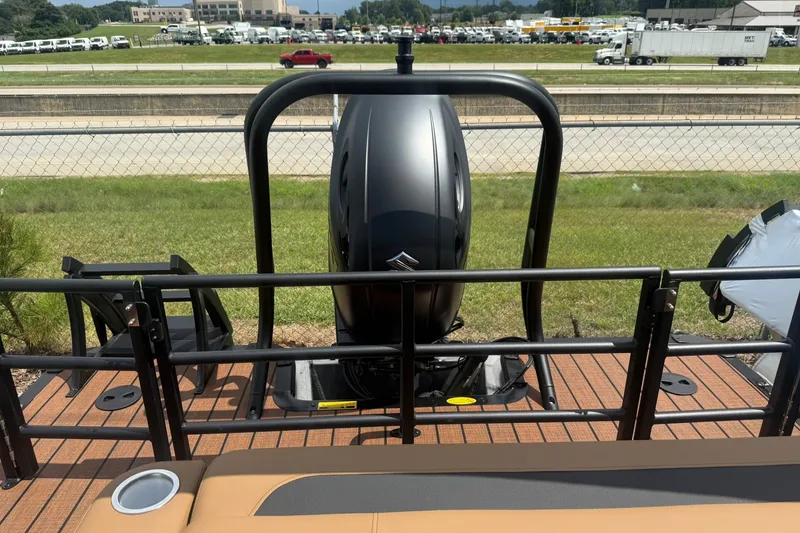 Slide: The Image of 2026 Bentley Pontoons Legacy 223 Swingback with outboard motor, parked near a highway. - 20