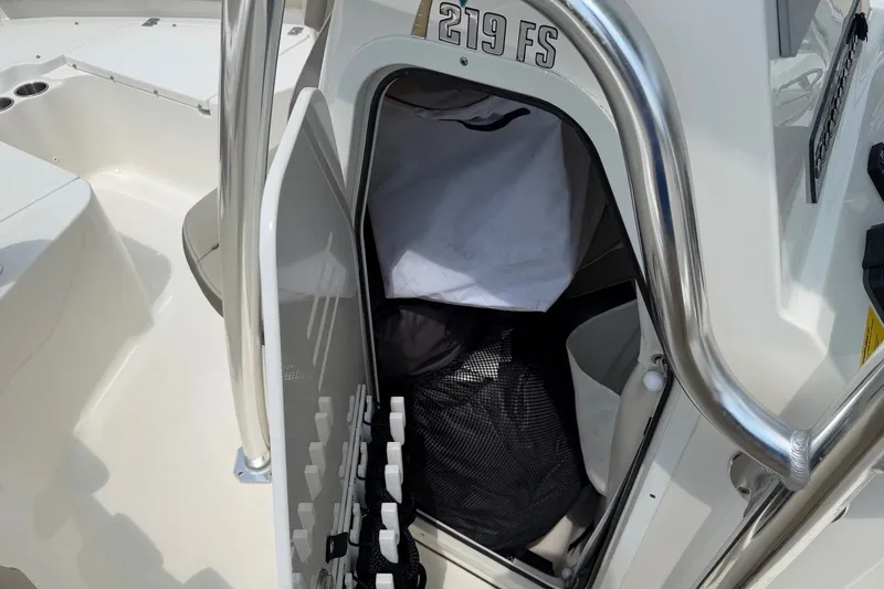 Slide: The Image of 2023 Key West 219 FS boat storage compartment with open door and visible gear. - 14