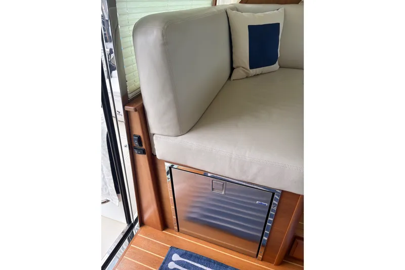 Slide: The Image of Interior of 2015 Sabre 38 Salon Express with cushioned seating and built-in refrigerator. - 16