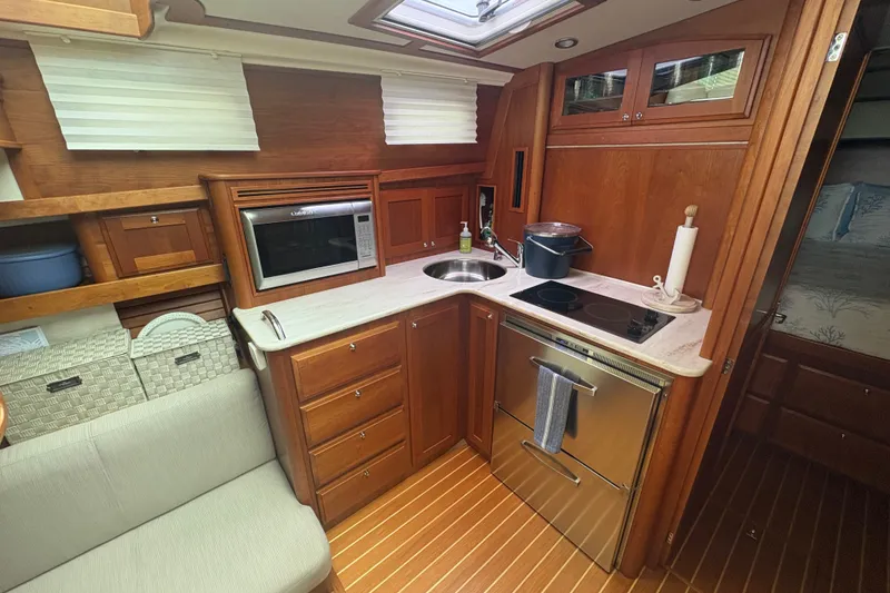 Slide: The Image of 2015 Sabre 38 Salon Express yacht kitchen with wood cabinetry and modern appliances. - 25