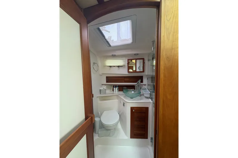 Slide: The Image of 2015 Sabre 38 Salon Express bathroom with skylight, glass sink, and wooden cabinetry. - 30