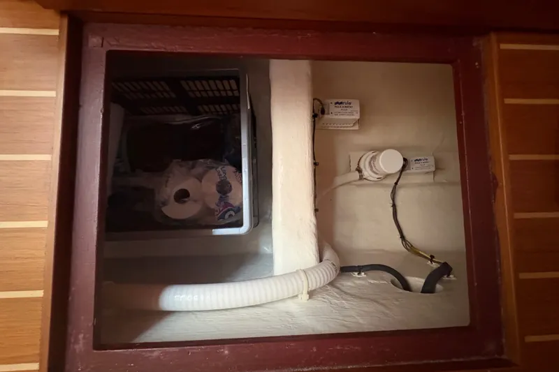 Slide: The Image of Storage compartment in a 2015 Sabre 38 Salon Express boat with plumbing and supplies. - 38