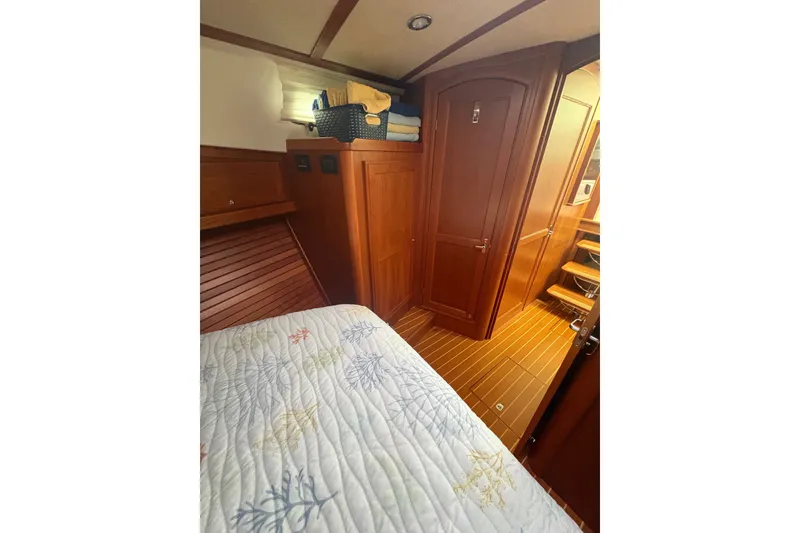 Slide: The Image of Interior of 2015 Sabre 38 Salon Express, featuring wooden cabinetry and cozy bedding. - 35