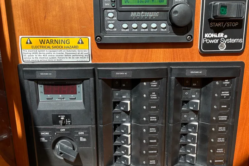 Slide: The Image of Electrical control panel on a 2015 Sabre 38 Salon Express boat with warning label. - 50