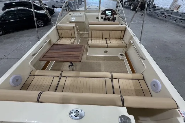 Slide: The Image of 2023 Rossiter 23 boat interior with beige seating and wooden table in a spacious layout. - 6