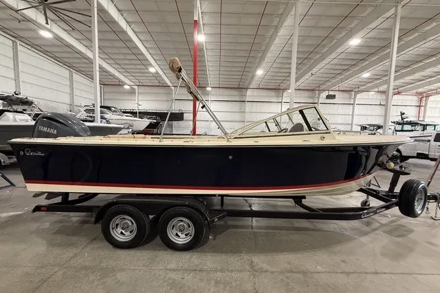 Slide: The Image of 2023 Rossiter 23 boat on trailer in indoor showroom setting. - 1
