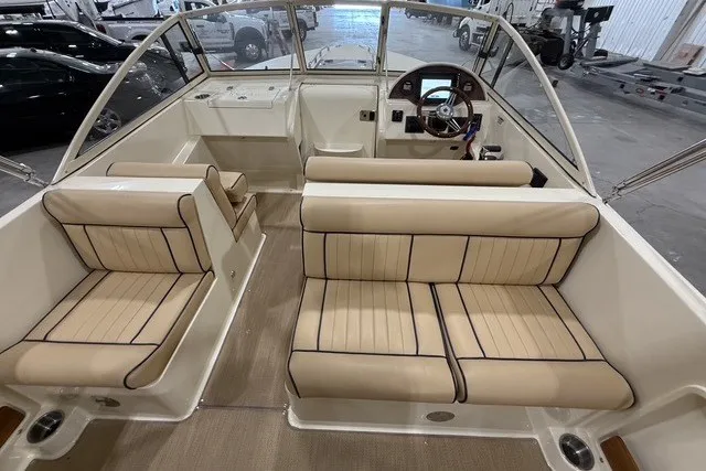 Slide: The Image of Interior of 2023 Rossiter 23 boat with beige seating and steering wheel. - 9