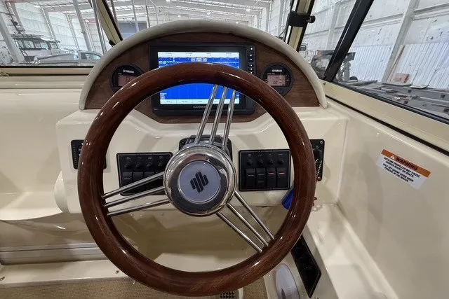Slide: The Image of Steering wheel and dashboard of 2023 Rossiter 23 boat with navigation display. - 13
